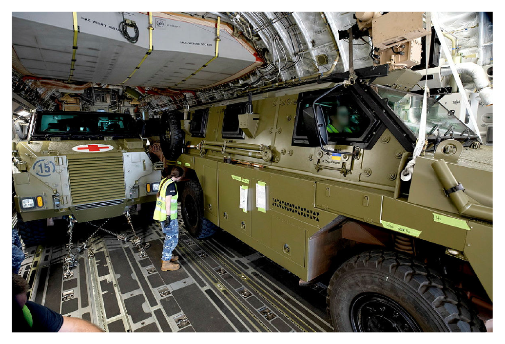 This is a photograph showing Bushmaster protected mobility vehicles being loaded onto a C-17A Globemaster III aircraft at RAAF Amberley
