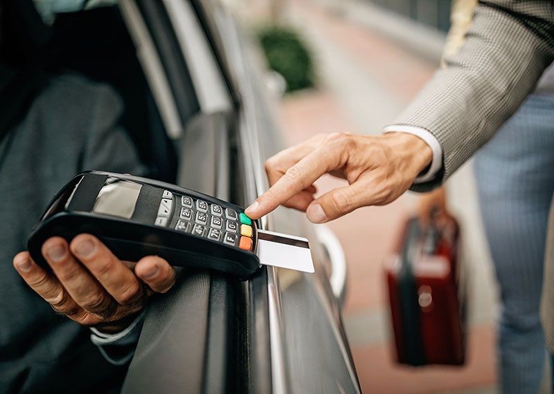 Person paying a taxi using a credit card.