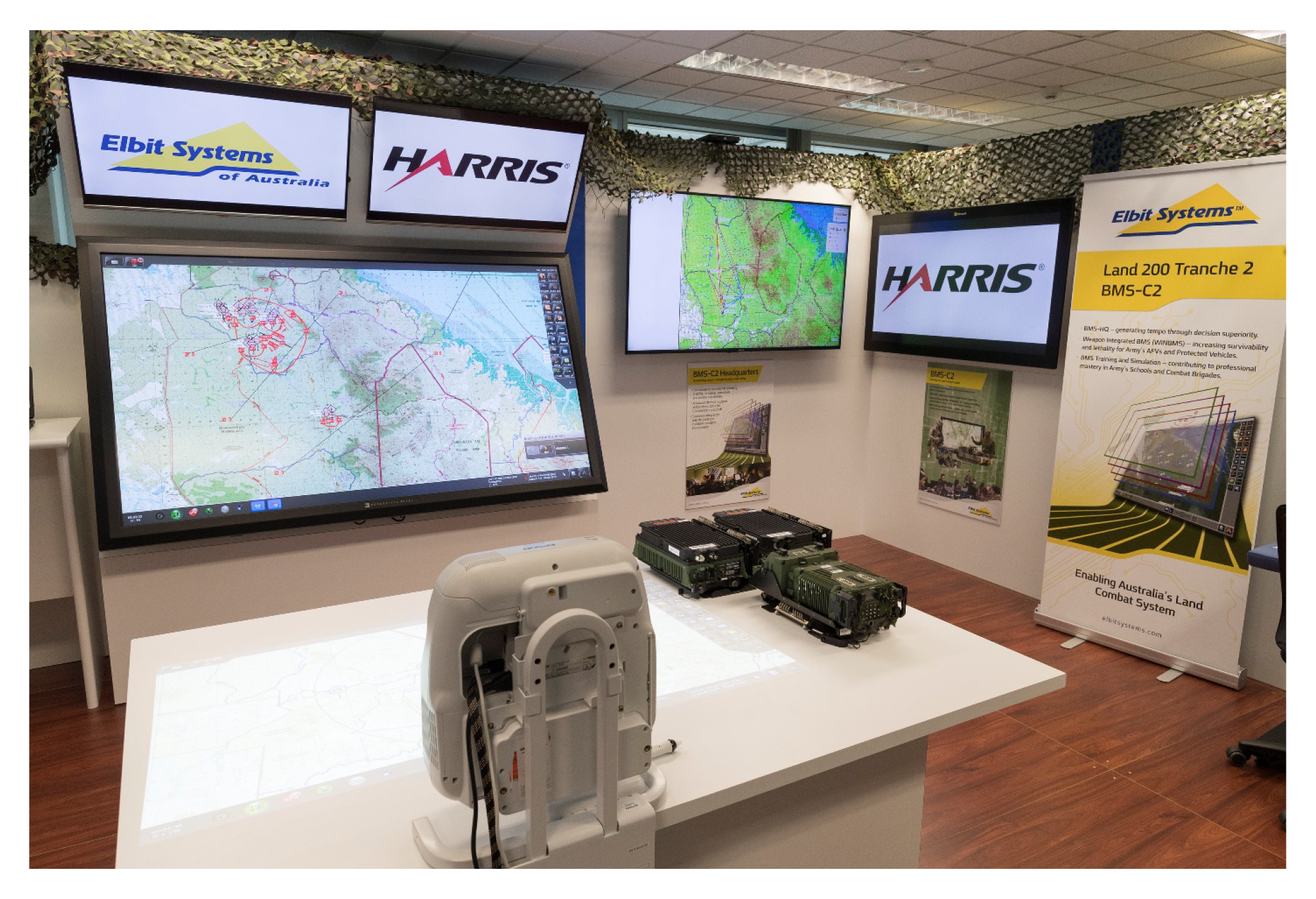 This is a photograph showing the setup of the parts of the Battle Management System. The screens and table illustrate Elbit’s Battle Management System, while the Harris radios provide the Combat Radio System for transmission of Battle Management System da This is a photograph showing the setup of the parts of the Battle Management System. The screens and table illustrate Elbit’s Battle Management System, while the Harris radios provide the Combat Radio System for transmission of Battle Management System da