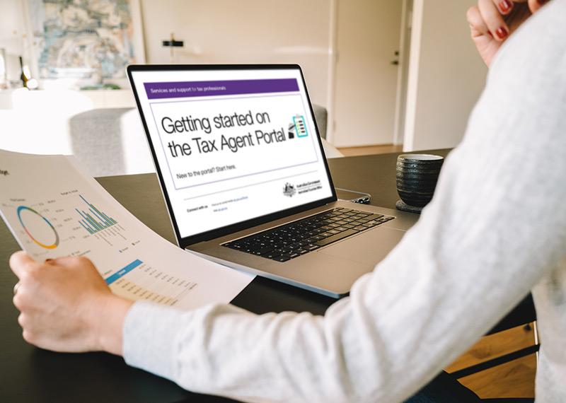 A person looking at a laptop that says getting started on the tax agent portal. 
