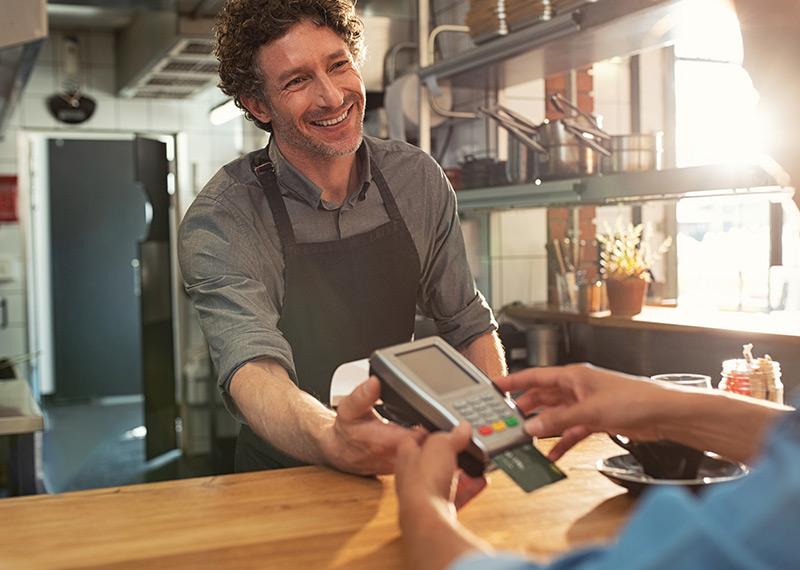 Image of a restaurant worker accepting payment by credit card